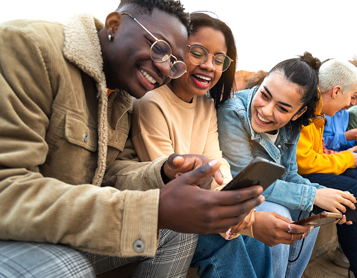 Youth connecting with each other while looking at a cellphone